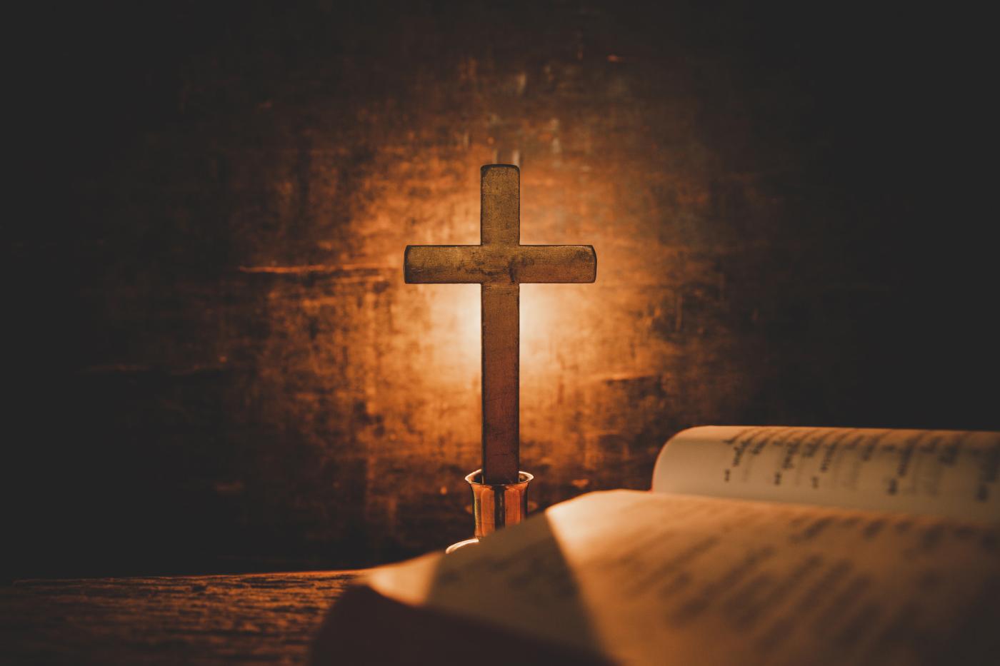 Open Bible on an oak table in warm candlelight